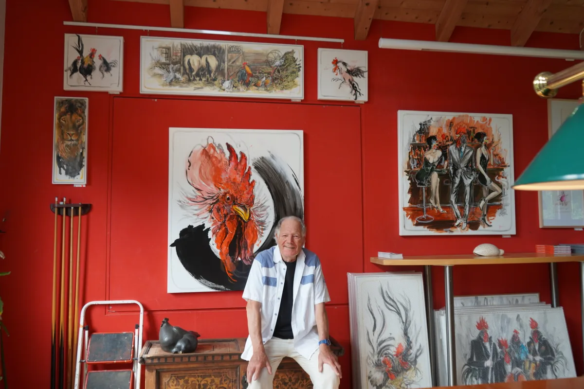 Man sieht Charly Bühler vor seinen Gemälden.